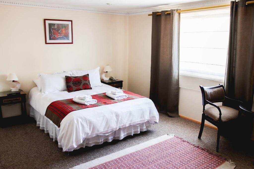 Double room at Hotel Rondo Viña del Mar with white linens, red woven runner and bright window light